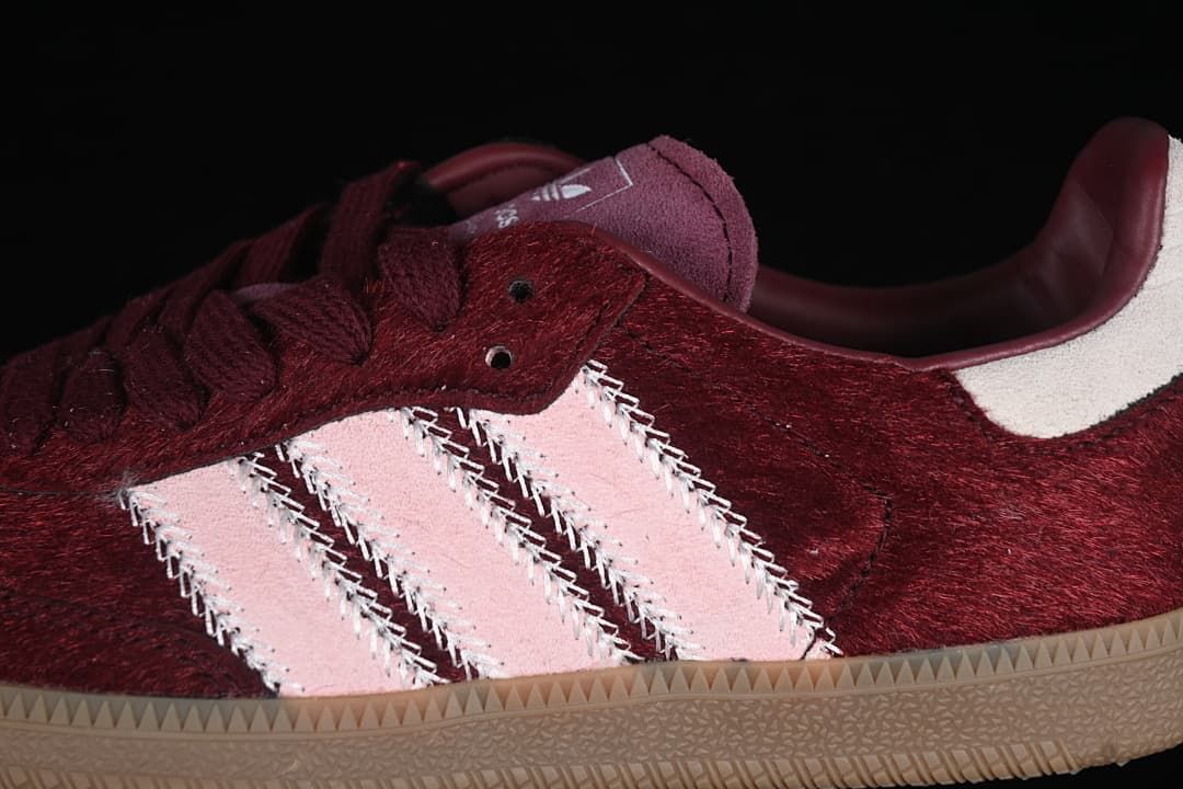 Close-up of pale pink side stripes against the burgundy upper