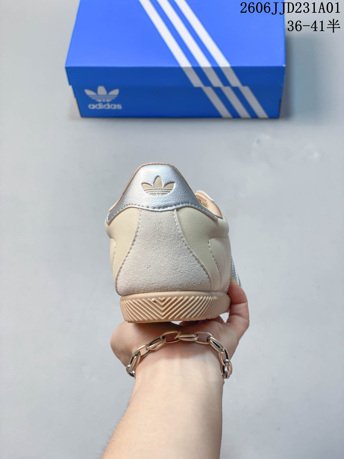 Rear view of a cream low-top sneaker with a silver heel tab and gum-colored outsole