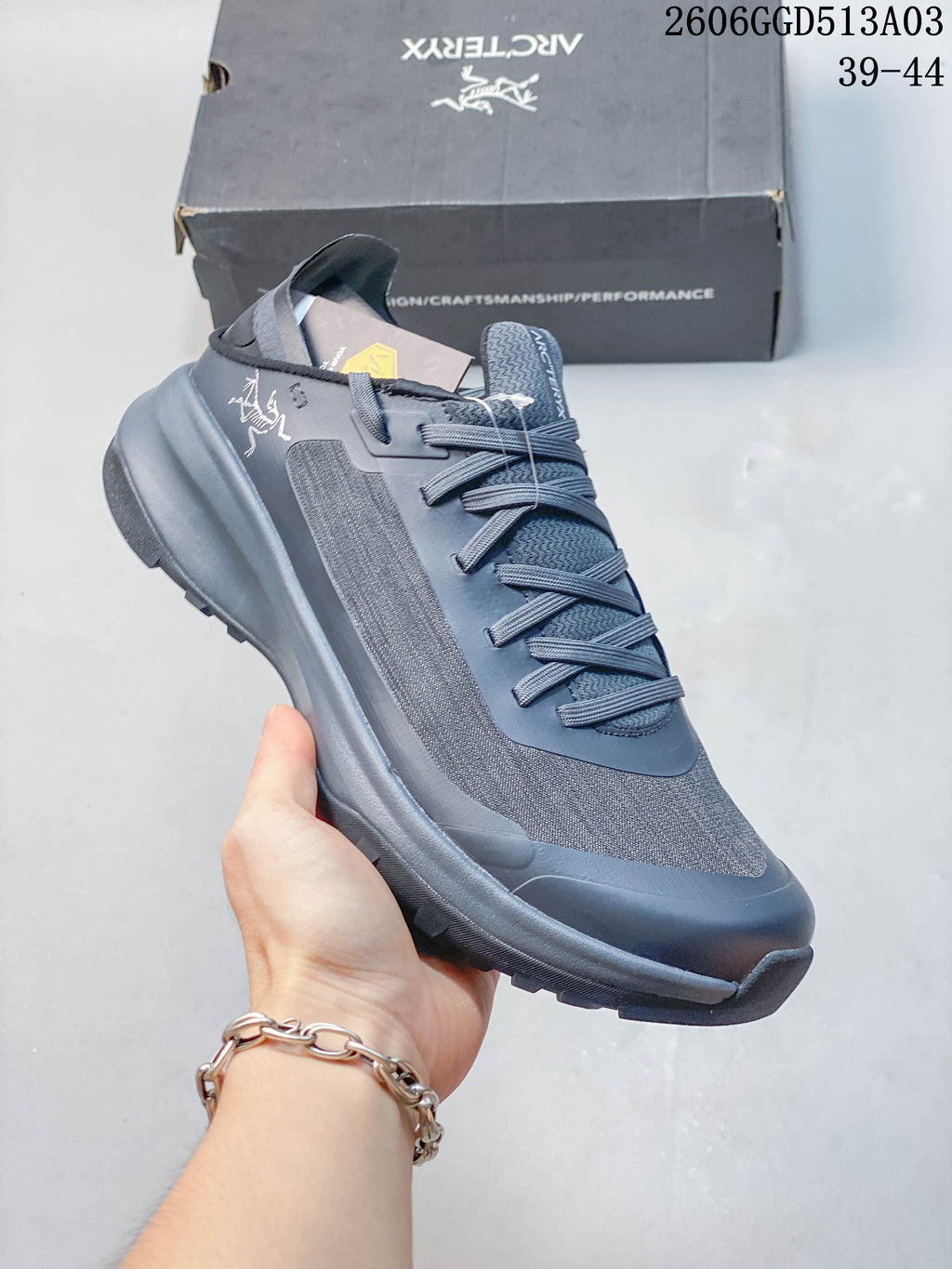 Angled side view of the gray-blue Arc'teryx outdoor shoe and its lugged sole.