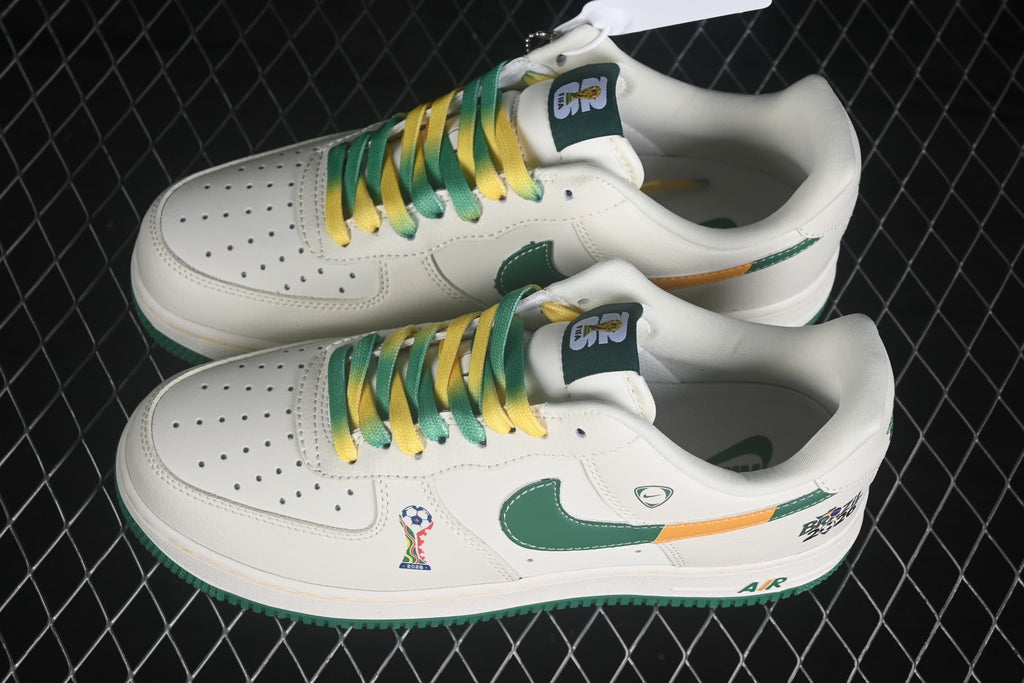 Pair of white Nike Air Force 1 '07 Low sneakers with green and yellow laces, green Swooshes, orange accents, and Brazil 2026 graphics.