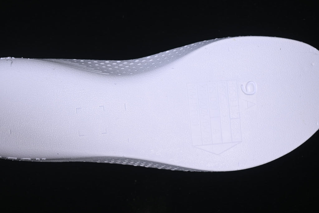 Close-up of a light-colored insole with embossed markings.