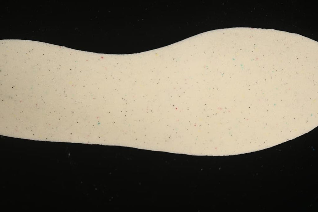 Light-colored shoe insole shown against a dark background