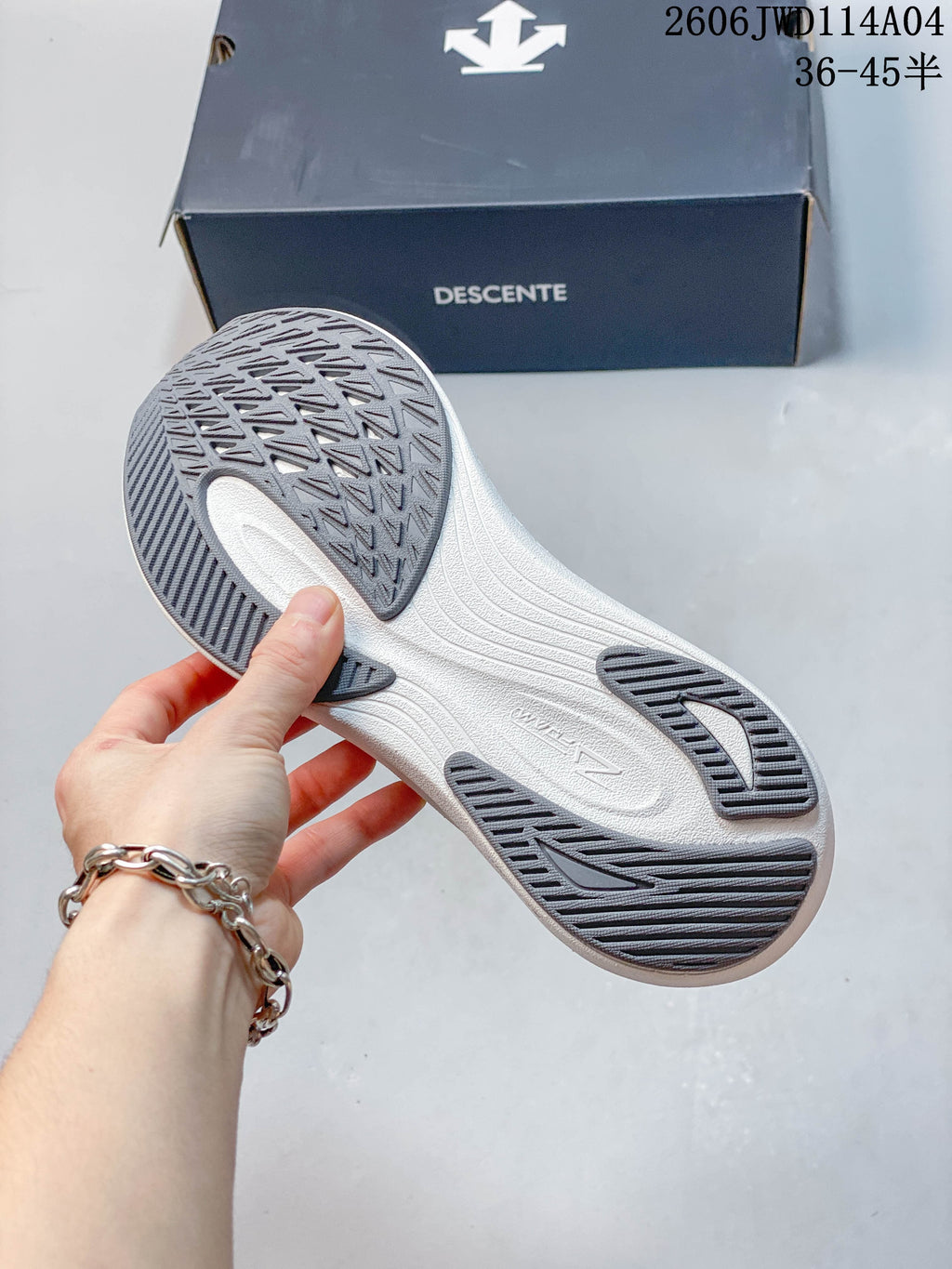 Close-up of the sneaker outsole showing patterned gray tread and a white midsole.
