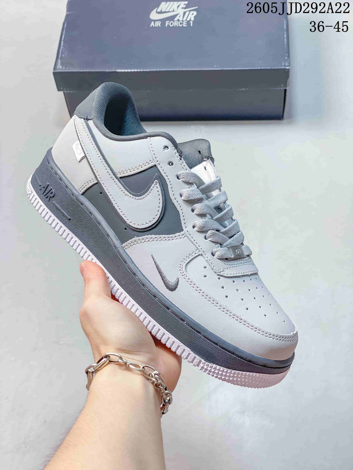 Gray and white low-top Nike Air Force 1 Shadow-style sneaker with layered panels and a dark gray sole.