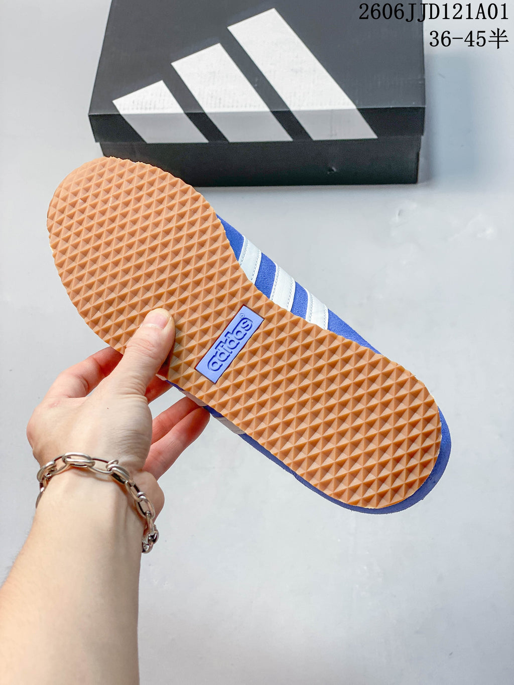 Close-up of the textured gum-colored outsole on a blue adidas sneaker