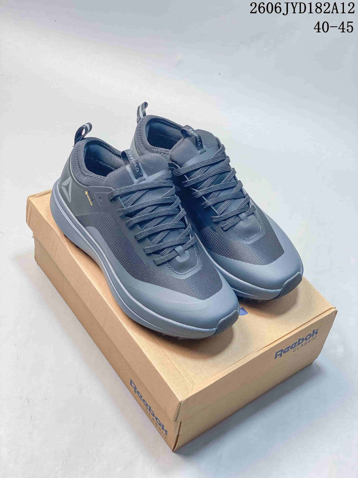 Pair of grey Reebok low-top sneakers displayed on a Reebok Classic box