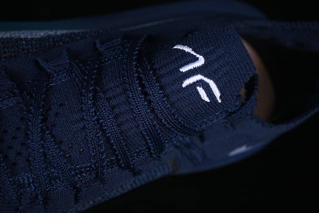 Close-up of the laces and tongue on the navy running shoe.