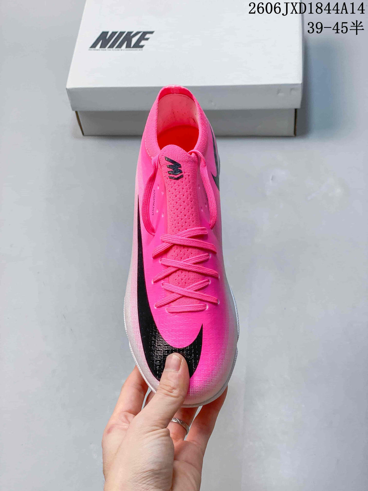 Top view of a pink Nike soccer cleat with black Swoosh and laces.