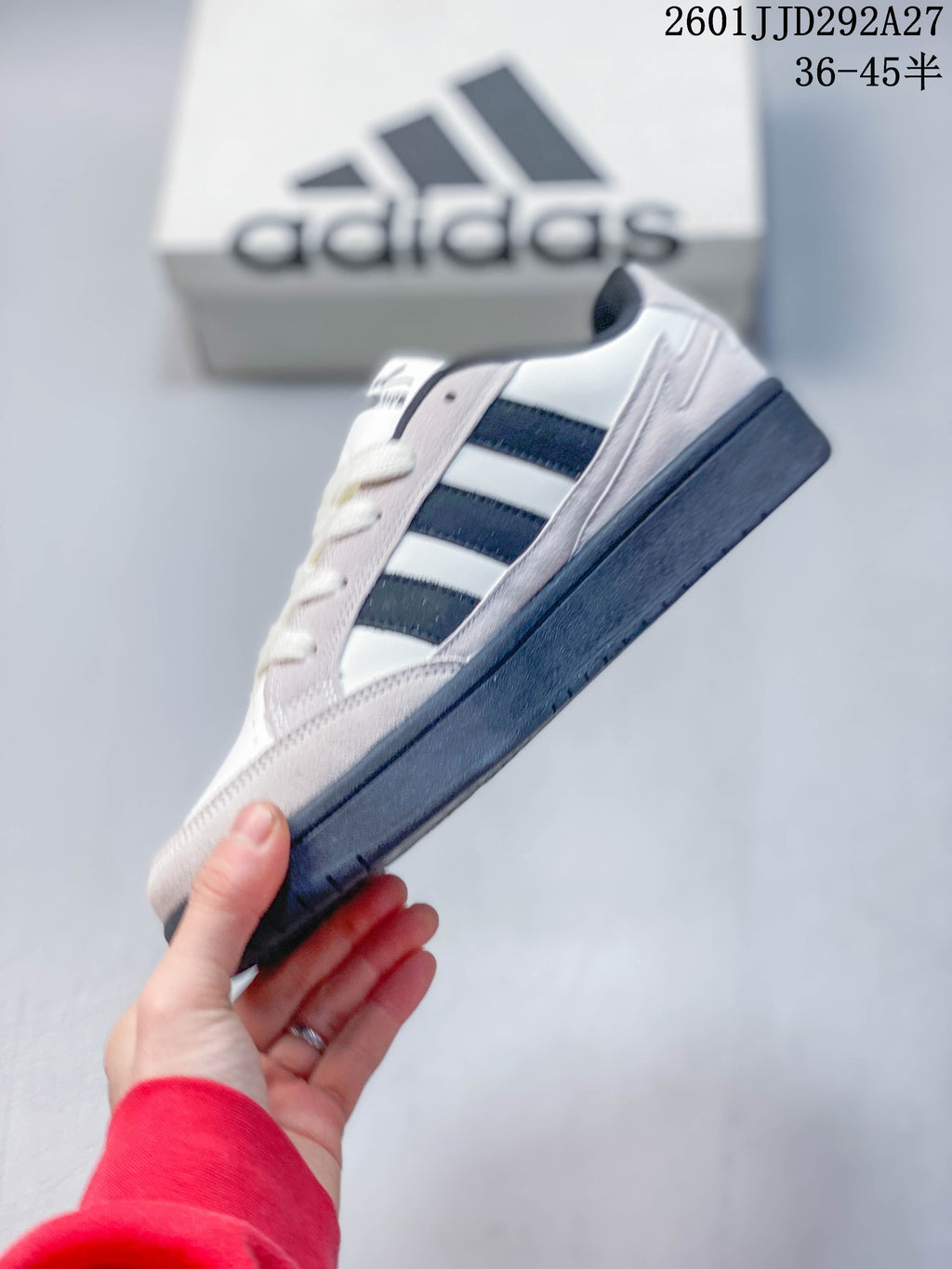 Side view of an Adidas Wcard Adv sneaker showing its dark stripes, light gray overlays, and dark outsole
