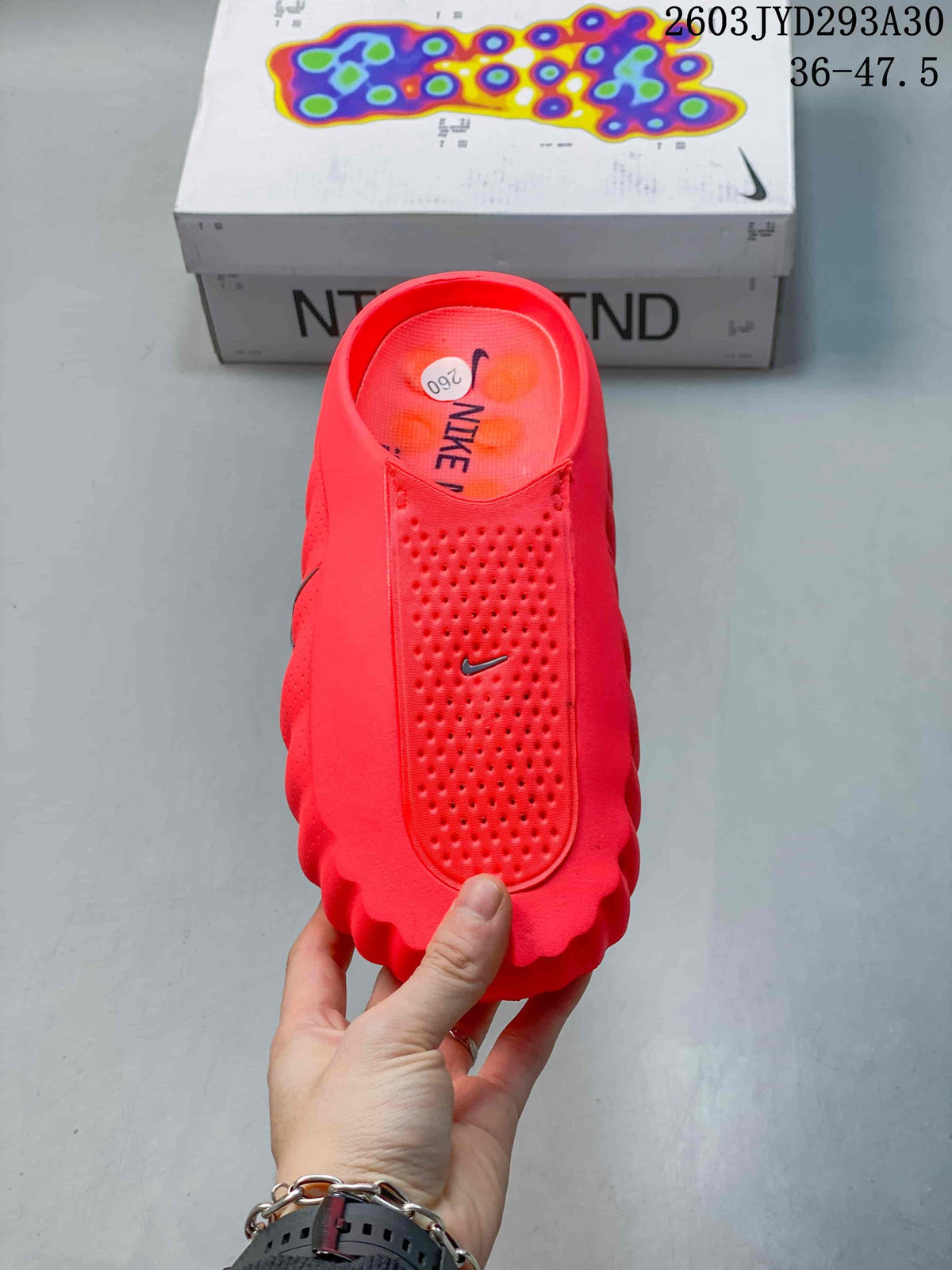 Top view of a bright red Nike Mind slide with a perforated upper panel.