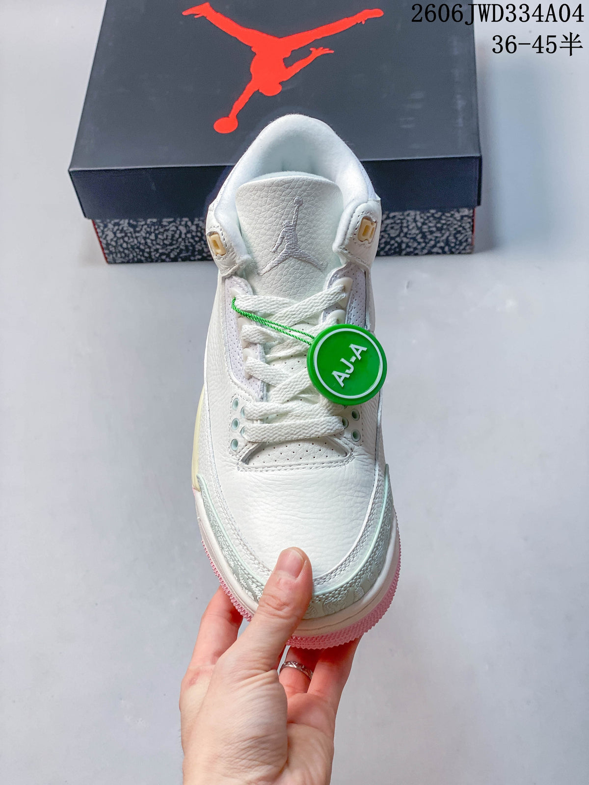 Front view of a white Air Jordan 3 Retro sneaker with pale mint details and pink outsole accents