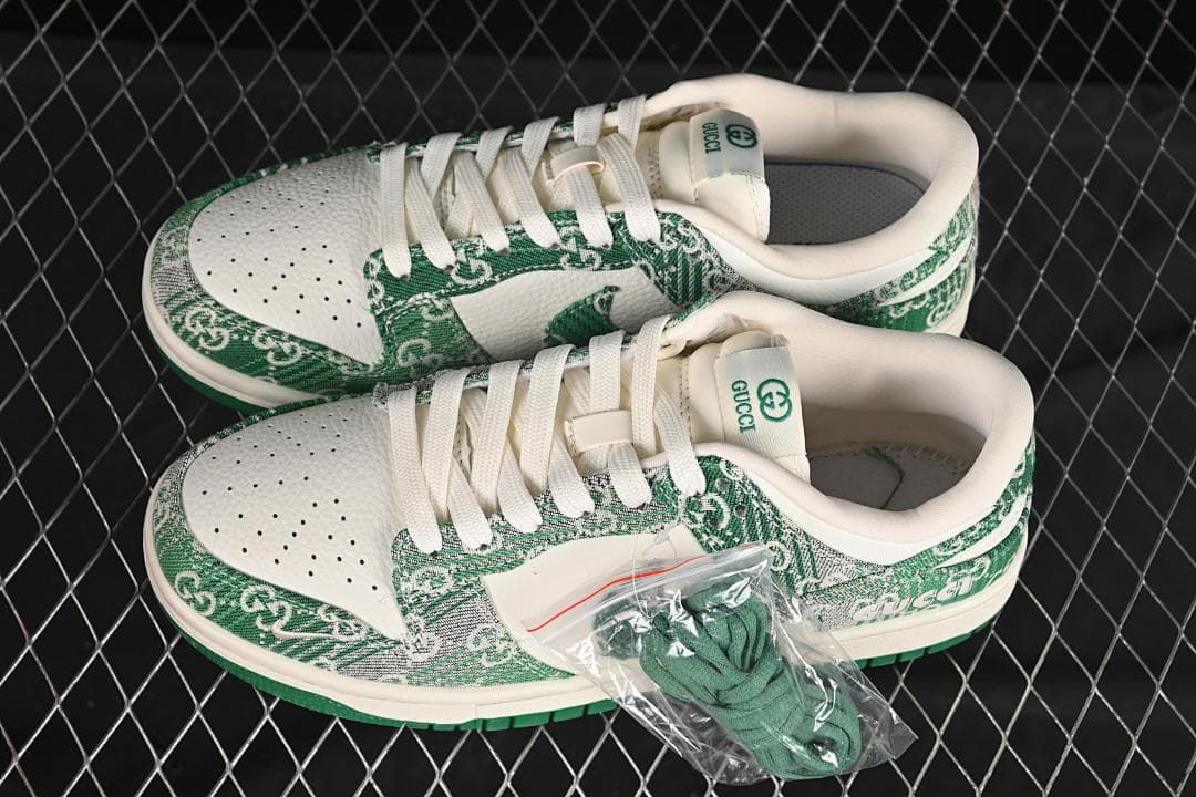 Pair of cream and green Nike SB Dunk Low sneakers with white laces and a spare set of green laces