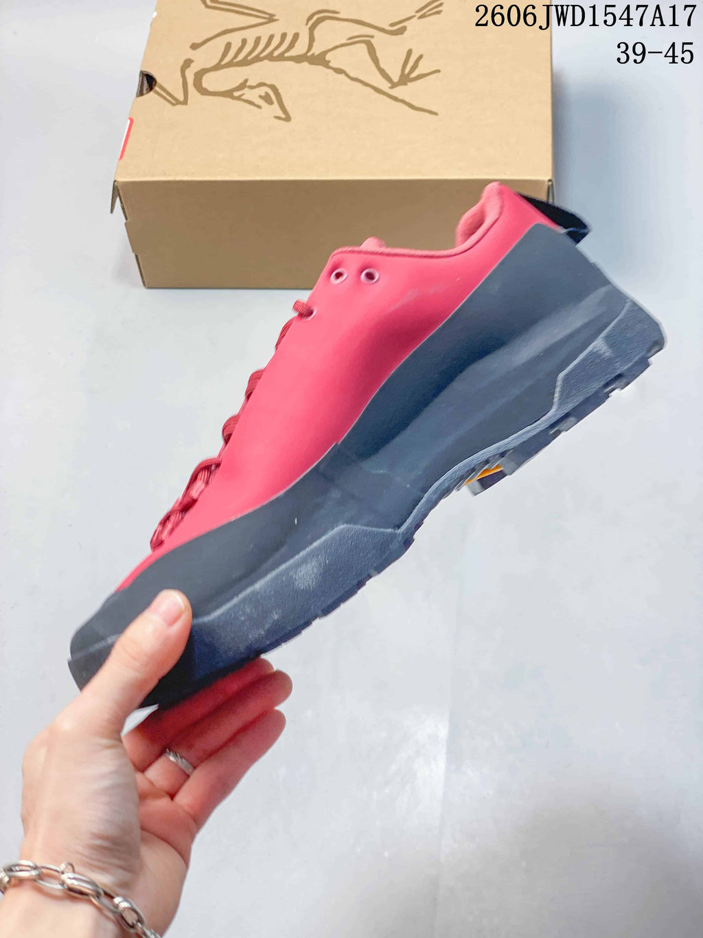 Side view of the coral-red and charcoal low-top shoe