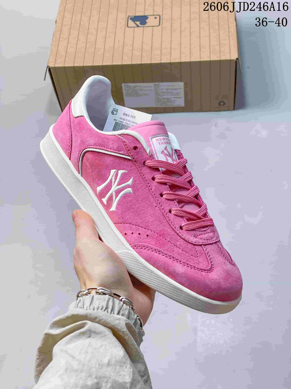 Close-up of a pink New York Yankees sneaker with white side graphics and a white sole.