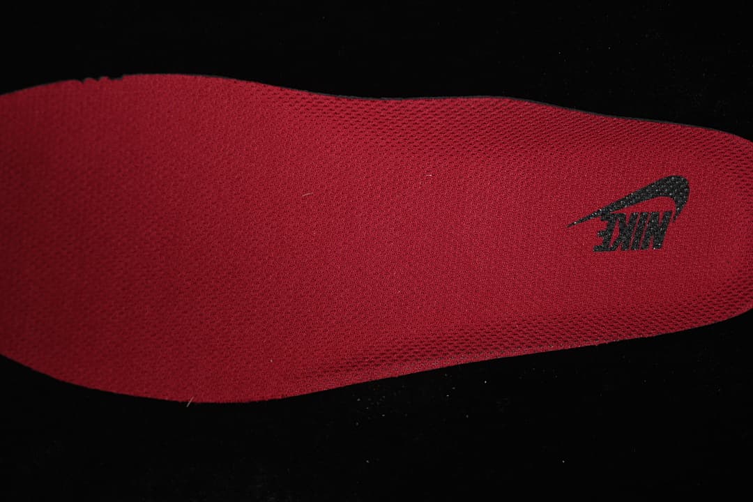 Close-up of a red insole with a dark logo