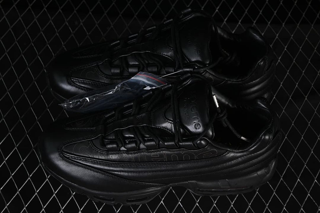 Pair of black sneakers with an extra lace packet