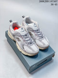 Pair of gray and pale pink New Balance 530-style mesh sneakers on a shoe box
