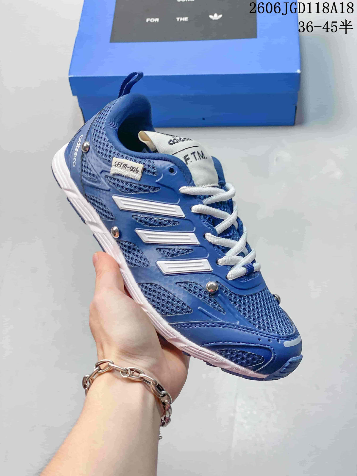 Angled side view showing the blue upper, SFTM tongue label and white outsole.