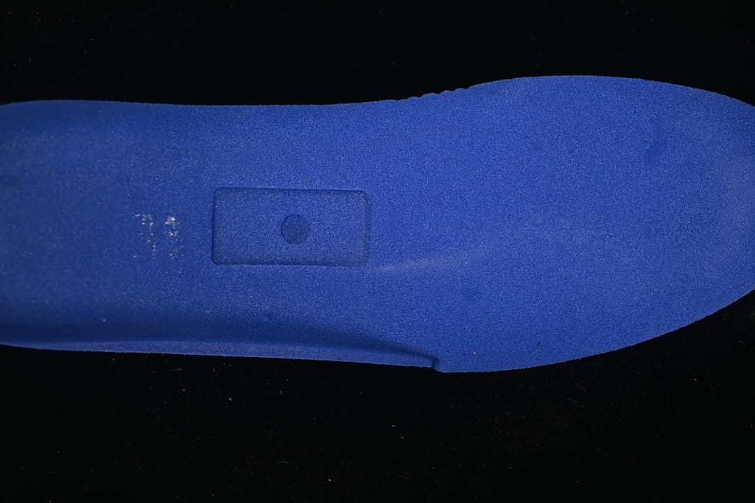 Blue shoe insert shown against a dark background