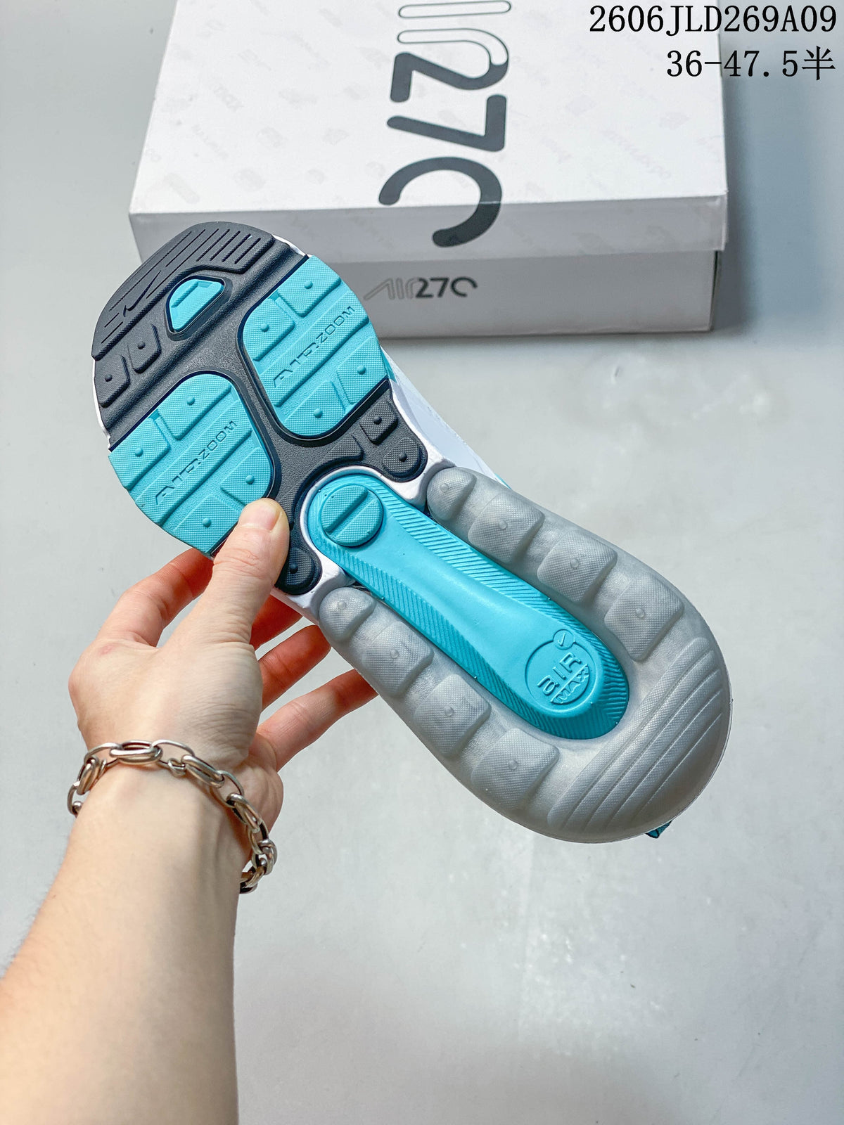 Underside of a Nike Air Max 270 sneaker showing a teal and dark outsole with a visible cushioning unit