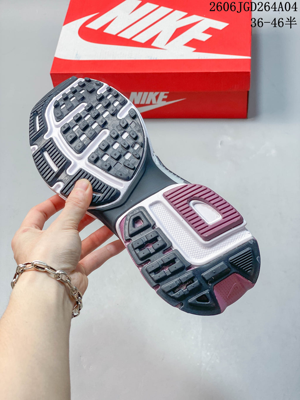 Close-up of the Nike V2K Run outsole with dark tread and plum-colored sections