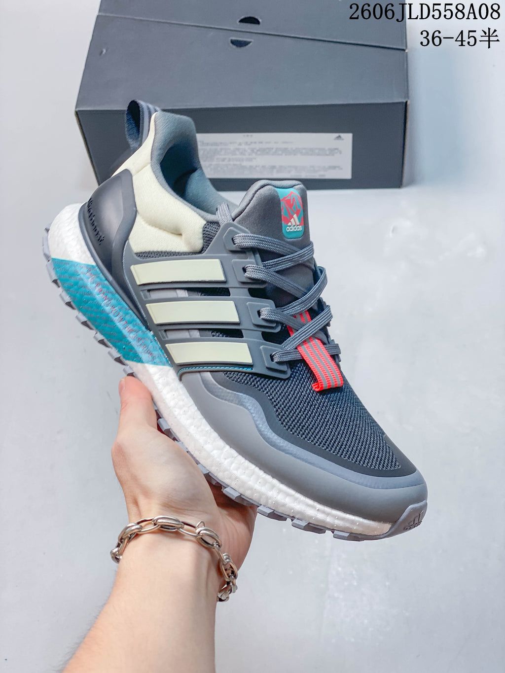 Angled side view of a grey Adidas sneaker with pale side stripes and a lugged outsole.