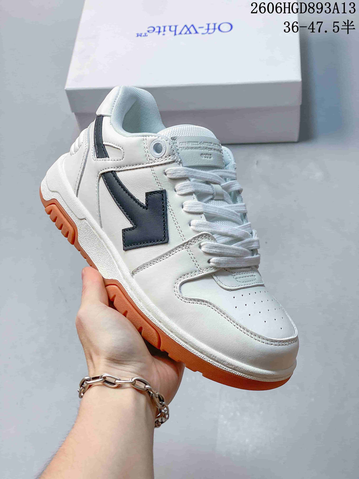 Angled side view of the white low-top sneakers with black accents and gum-colored tread.