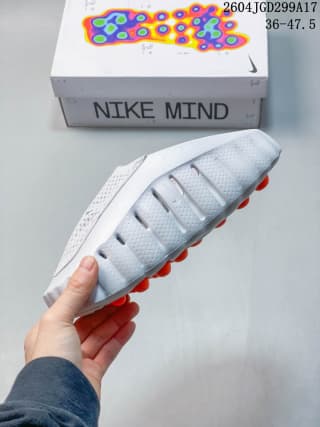 Side profile of the white slide showing the textured upper, segmented midsole, and orange outsole elements.