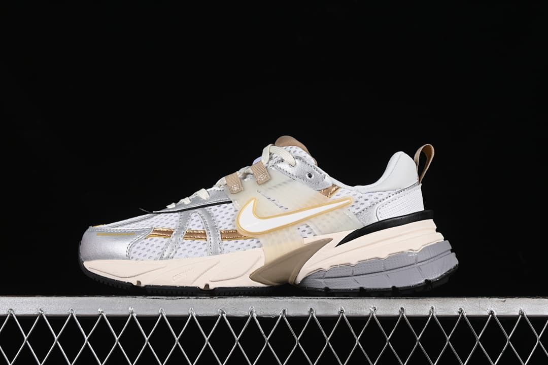 Side view of the Nike V2K Run in gray, white, silver and tan-gold.