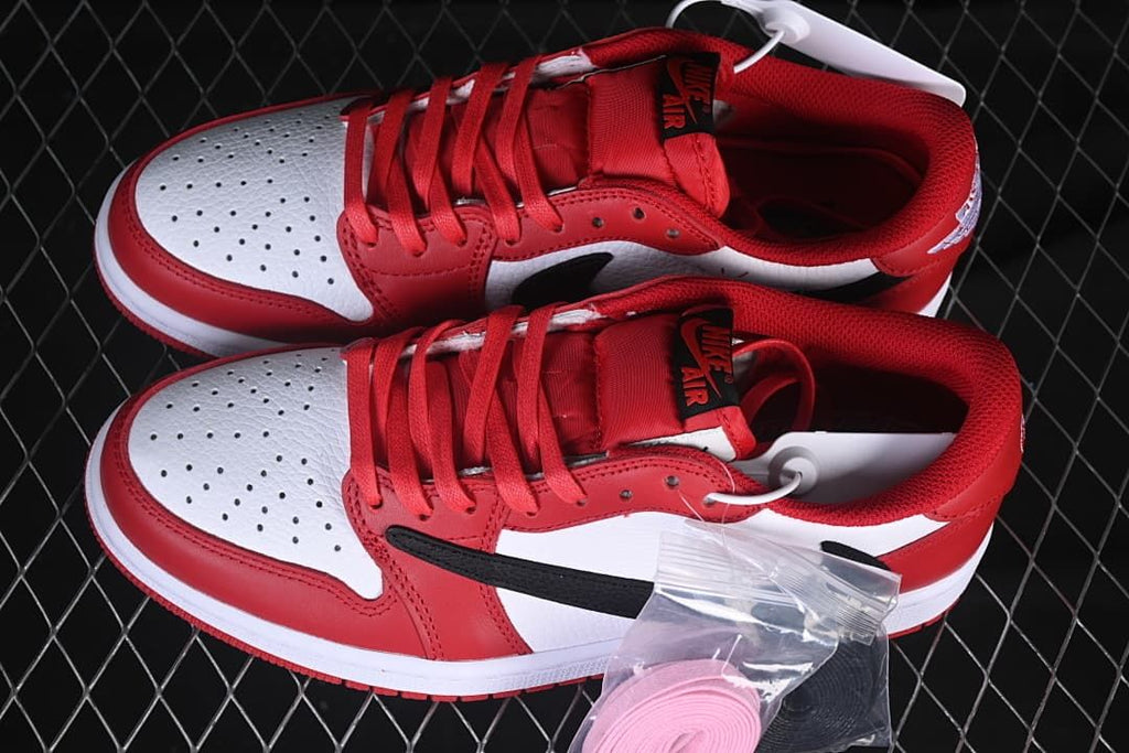 Pair of red, white and black low-top sneakers with extra laces pictured.