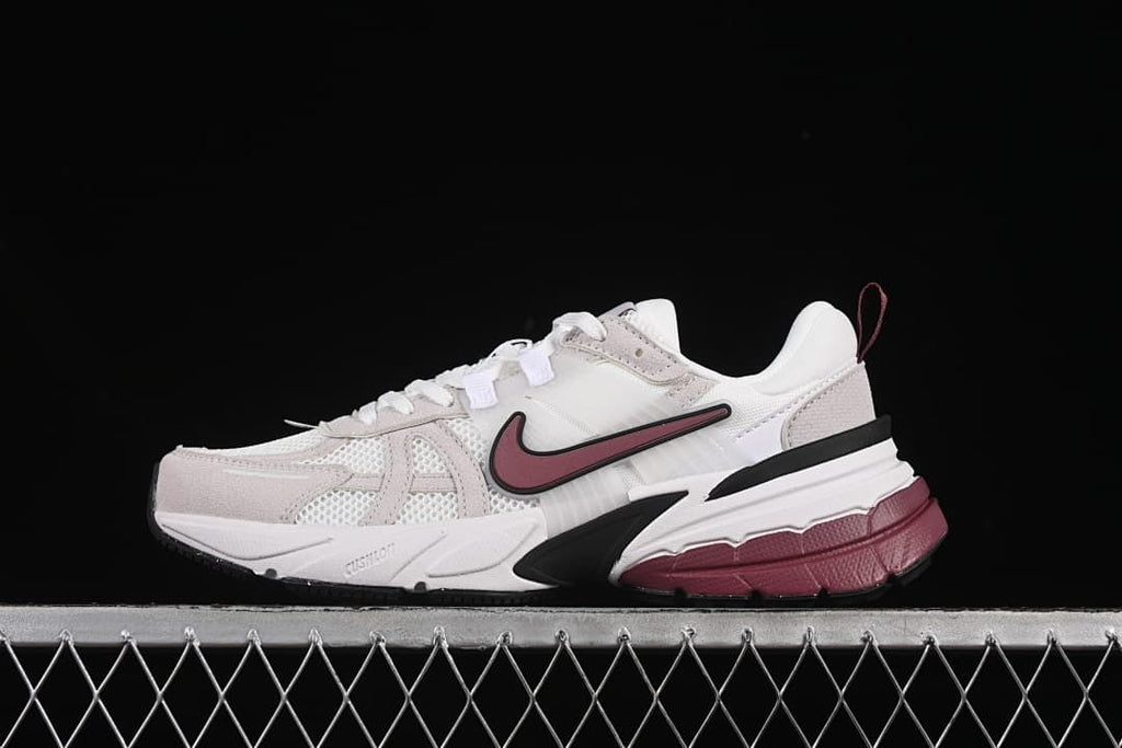Side view of Nike V2K Run sneakers in white, light neutral, burgundy, and black