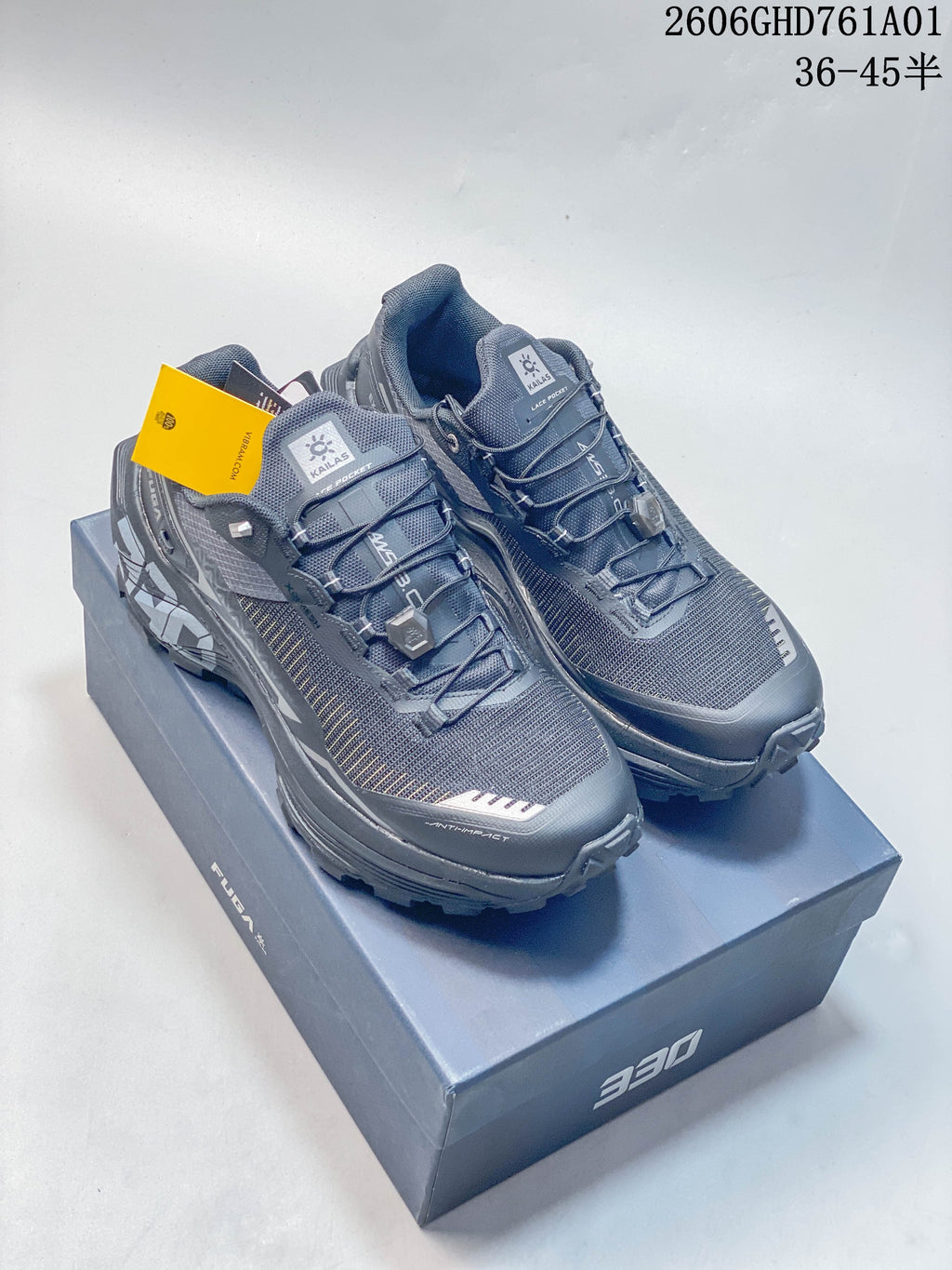 Pair of charcoal gray Kailas FUGA EX330 trail running shoes on a shoebox