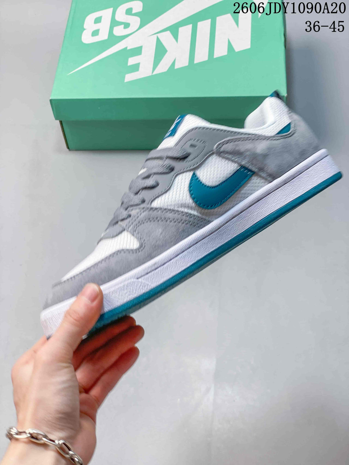 Side view of the gray, white, and teal low-top shoe