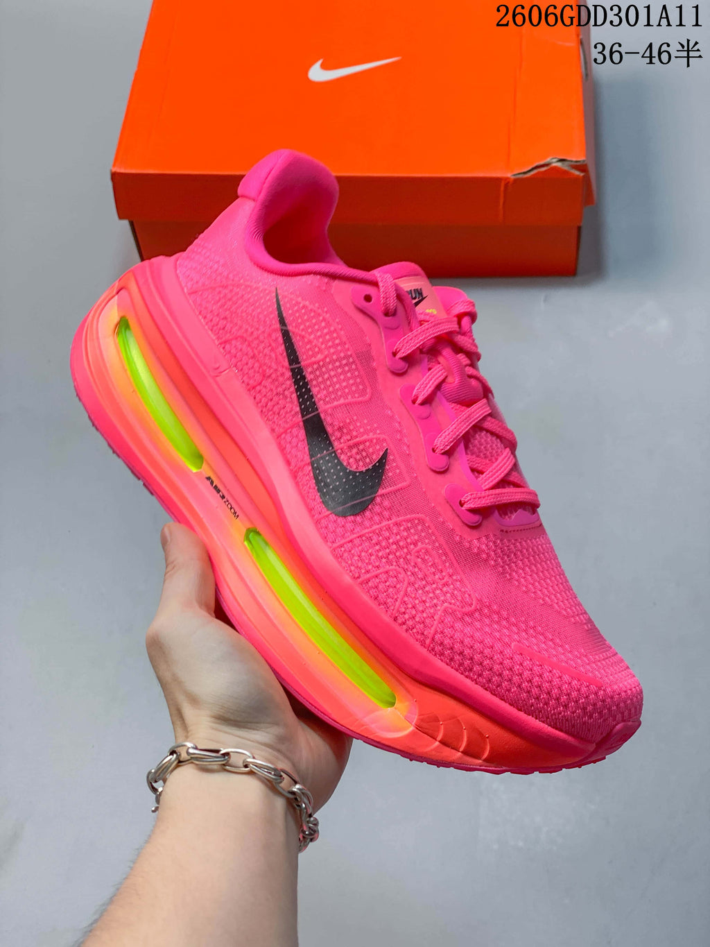 Angled side view of the hot-pink Nike Vomero Premium running shoe with black Swoosh and bright contrasting sole accents.