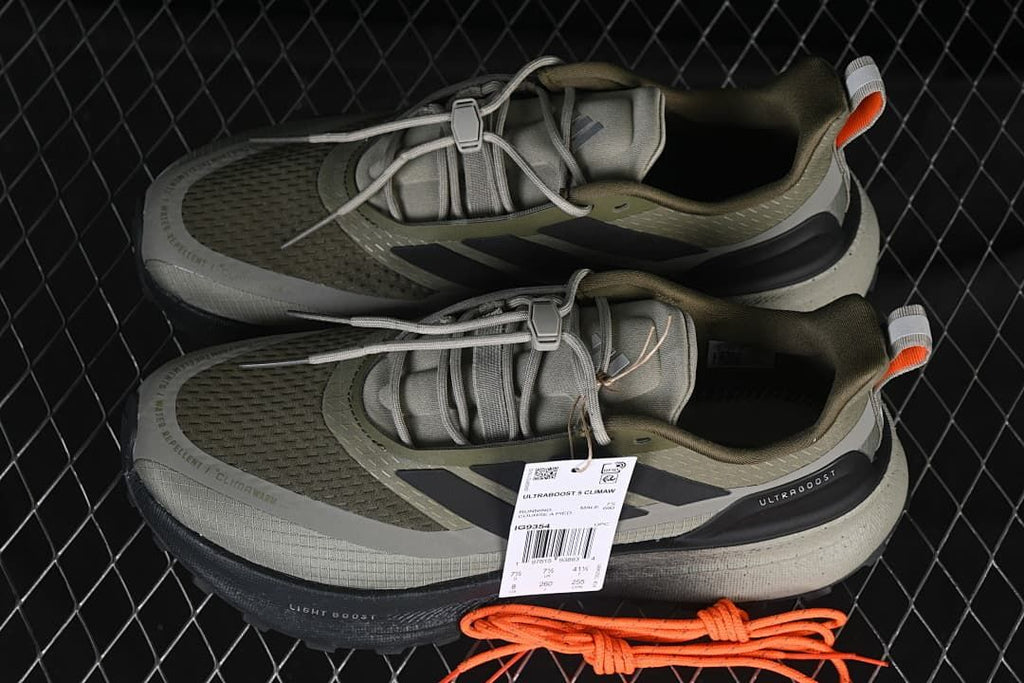 Pair of olive and gray shoes with a spare orange lace set
