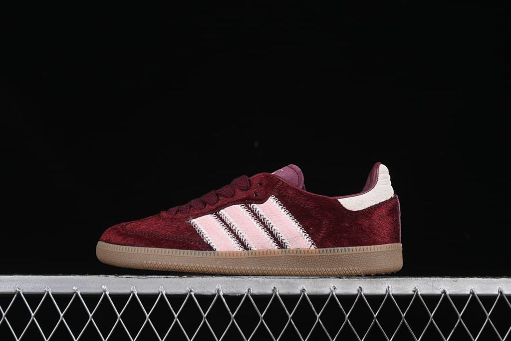 Side view of burgundy Adidas Samba OG sneakers with pale pink stripes and gum-colored sole
