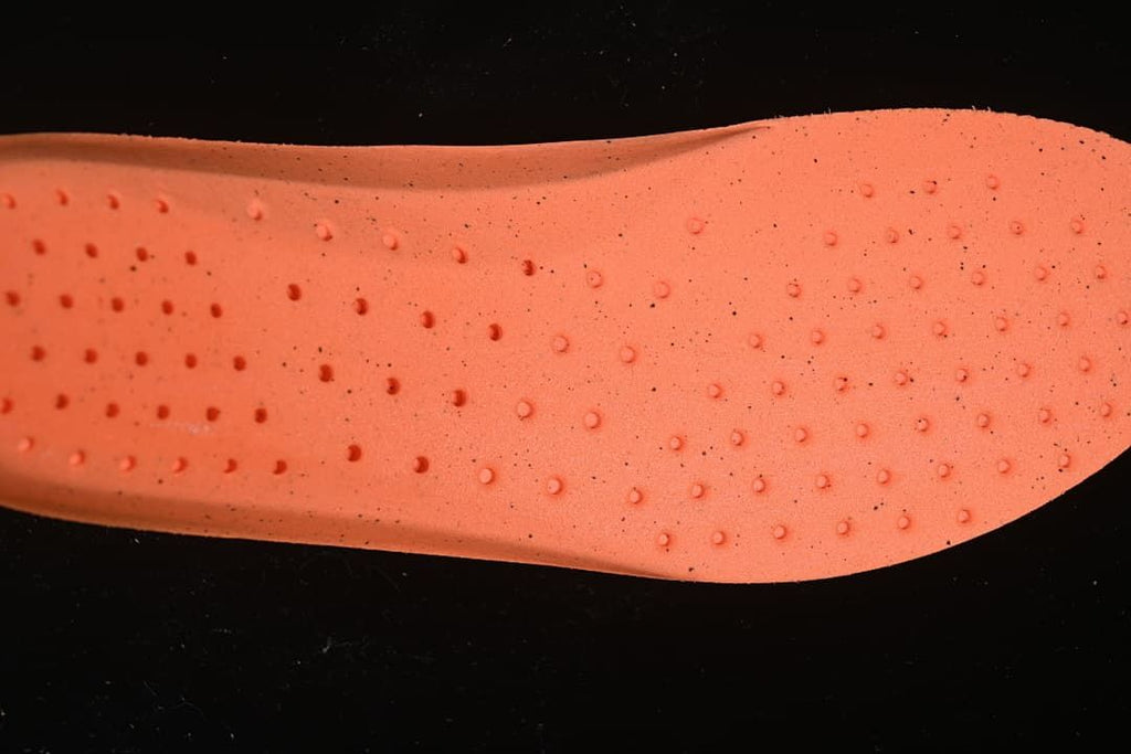 Close-up of orange shoe insert with raised dot pattern