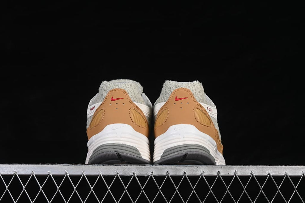 Rear view of the sneakers showing tan heel panels and red accents