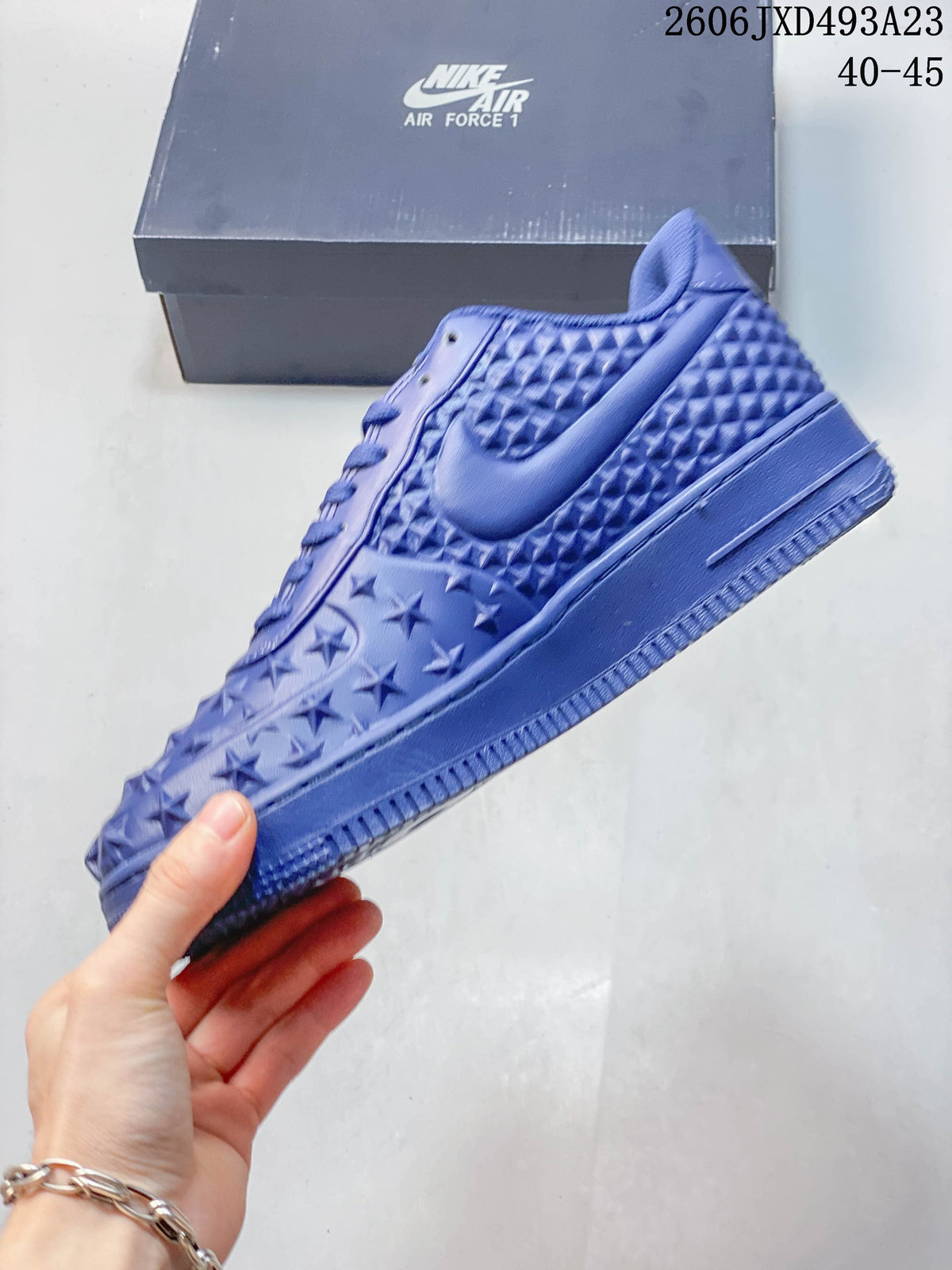 Side view of a blue Nike Air Force 1 sneaker showing raised star and geometric patterns