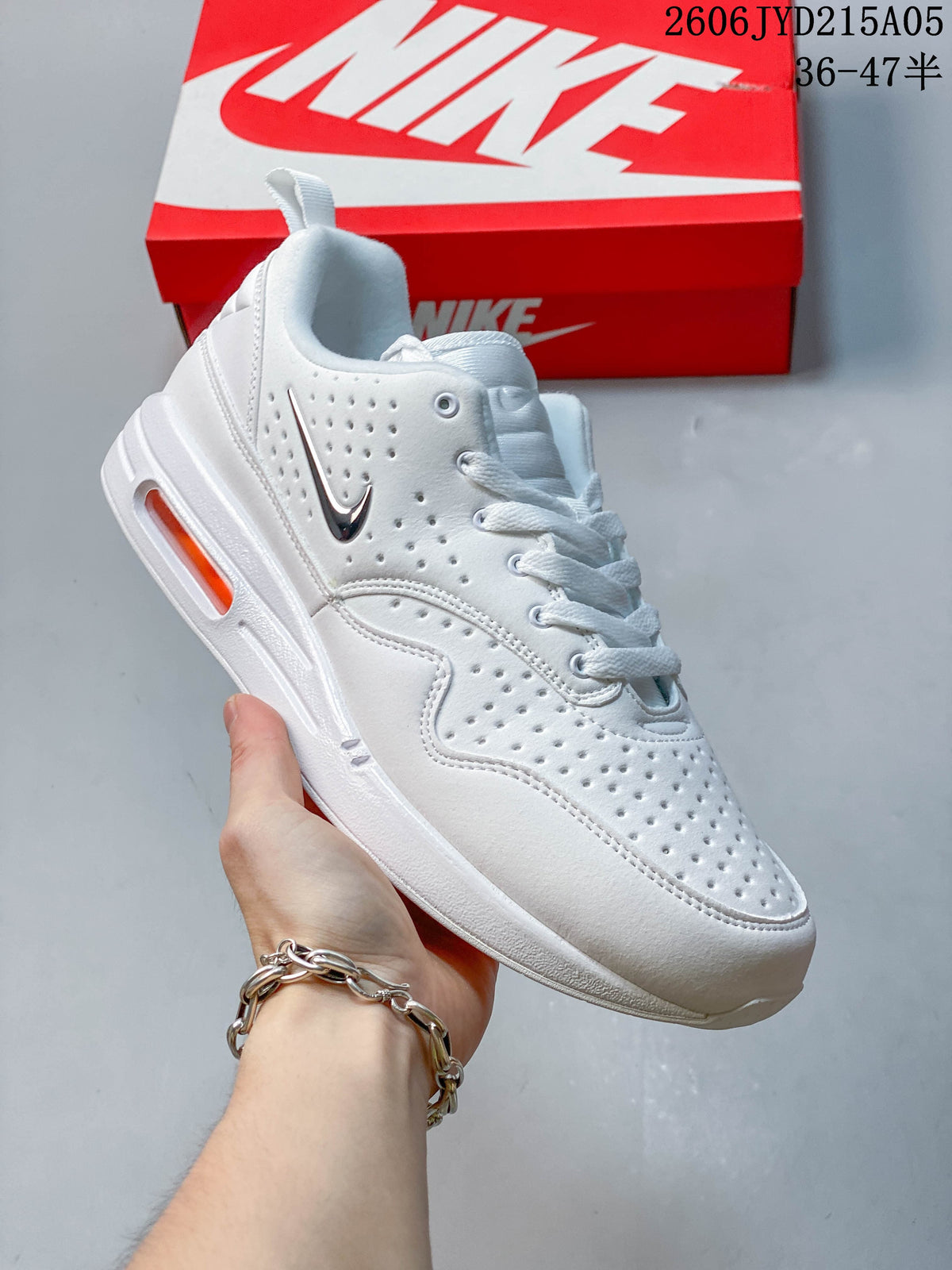 Angled side view of the white sneaker with dark Swoosh and orange midsole window