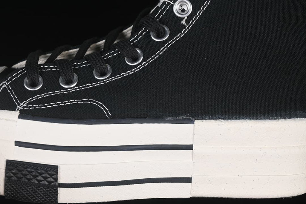 Close-up of black laces, metal eyelets, contrast stitching and layered sole