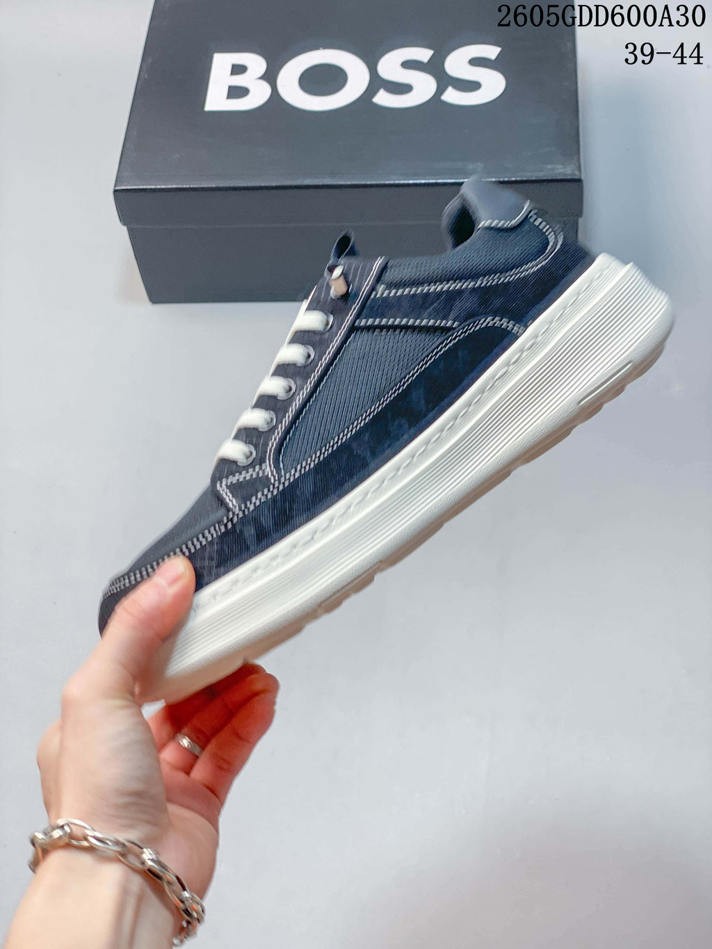 Side view of a navy low-top sneaker with contrast stitching, white laces, and a thick off-white sole; image overlay states sizes 39–44.