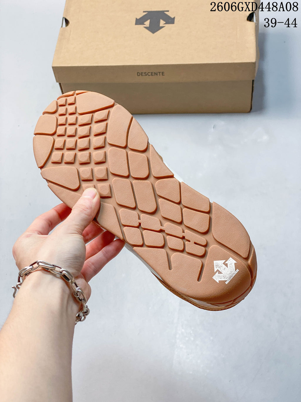 Close-up of the patterned brown outsole on a DESCENTE Chron Velo sneaker