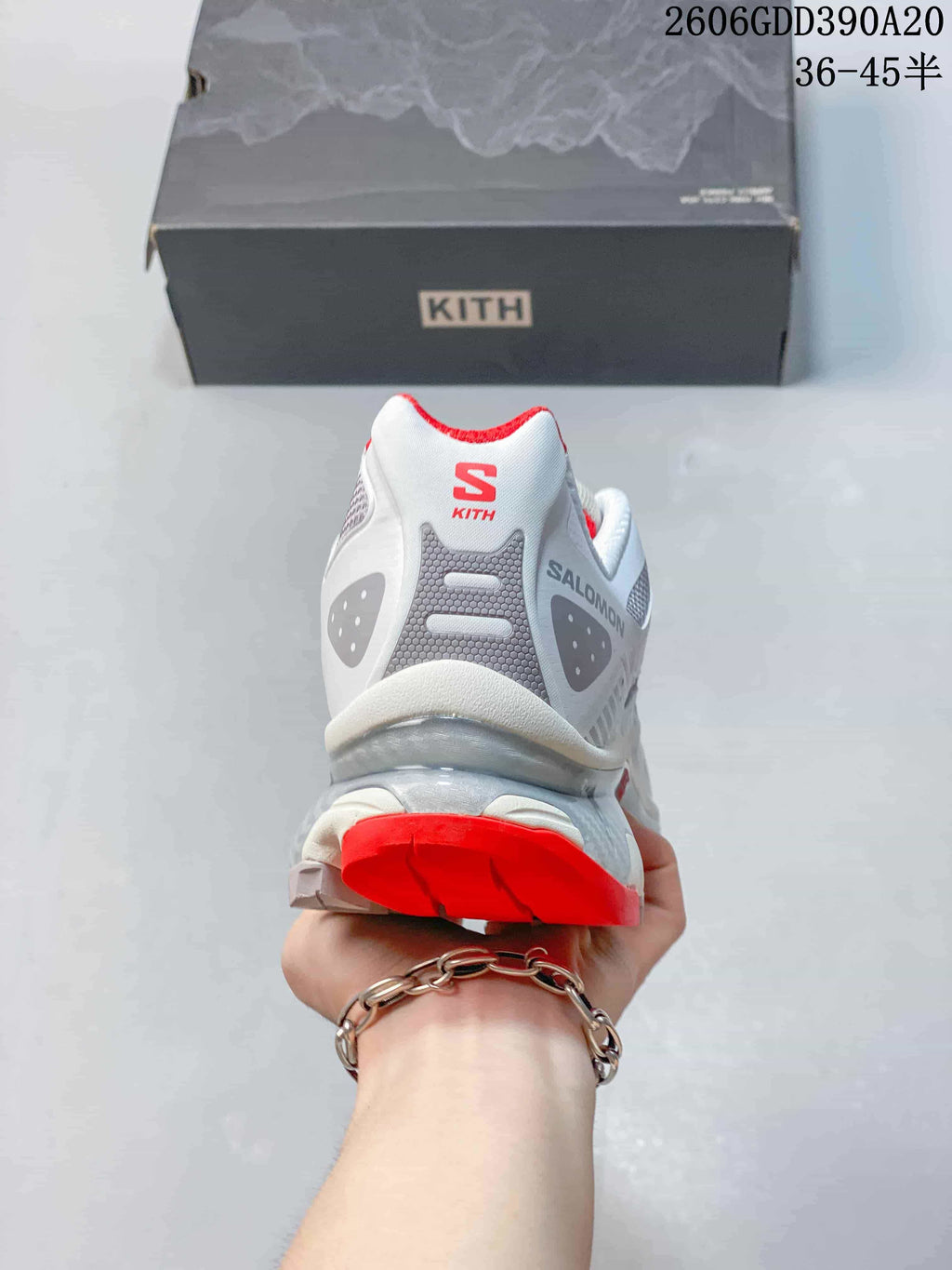 Rear view of the white shoe with red heel lining and Salomon and Kith branding