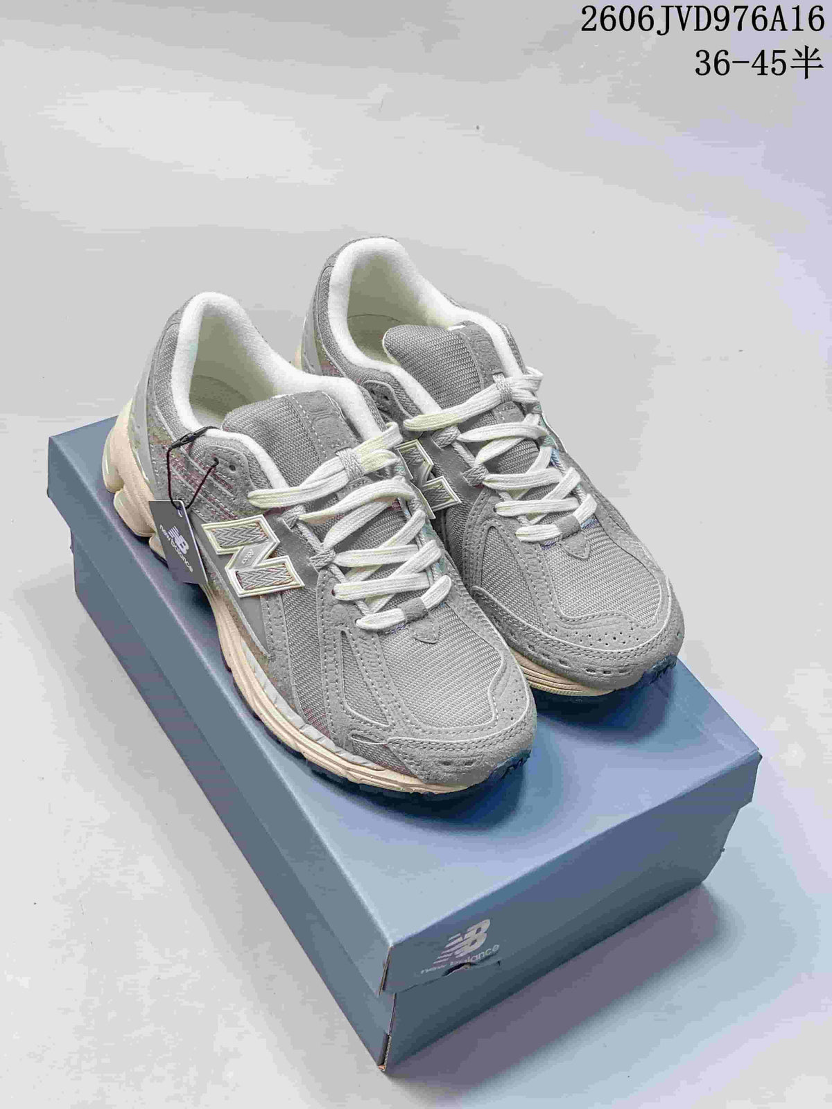 Pair of grey New Balance M1906RKC sneakers displayed on a shoe box.