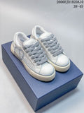 Pair of white and gray Dior B33 low-top sneakers with thick gray laces on a blue box