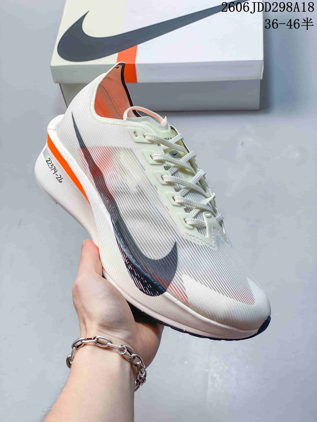 Side view of an off-white Nike Vaporfly shoe with dark Swoosh detail and orange heel accent