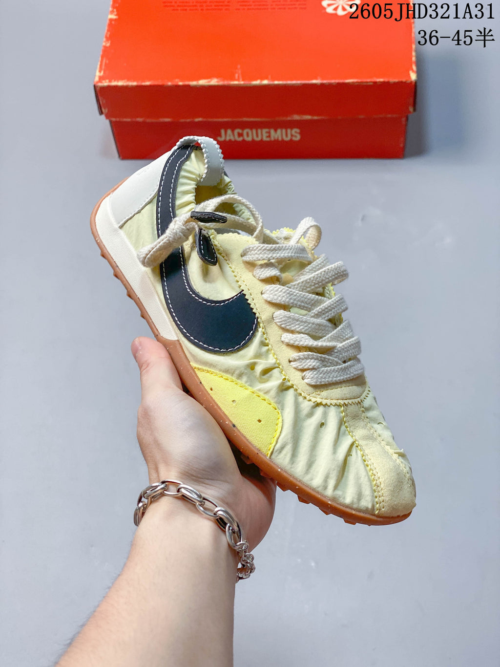 Angled side view of a pale yellow Nike x Jacquemus sneaker