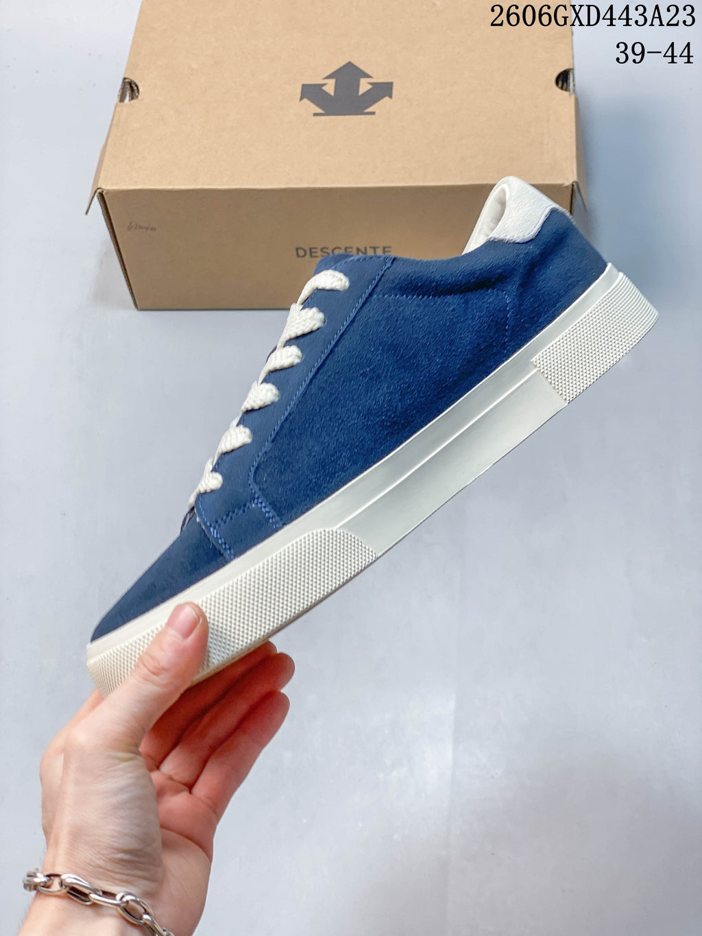 Side view of the navy low-top sneaker with a light-colored sole and cream heel accent.