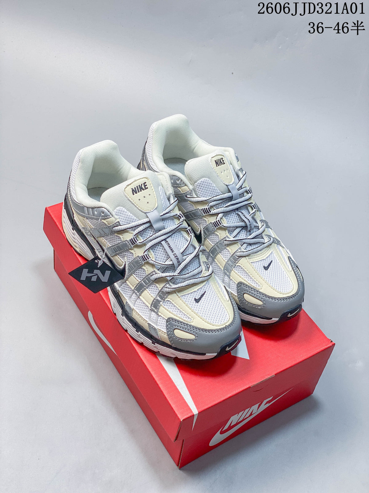 White and gray Nike P-6000 sneakers with pale yellow accents on a red shoe box